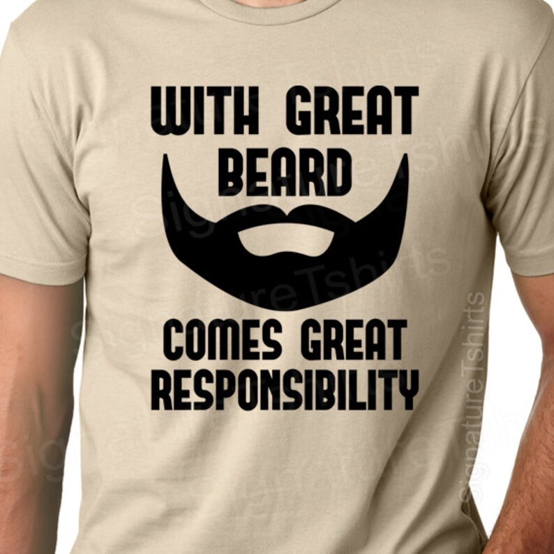 Pode incluir: Uma camiseta bege com texto preto que diz "With Great Beard Comes Great Responsibility". Uma silhueta preta de uma barba est&aacute; acima do texto.
