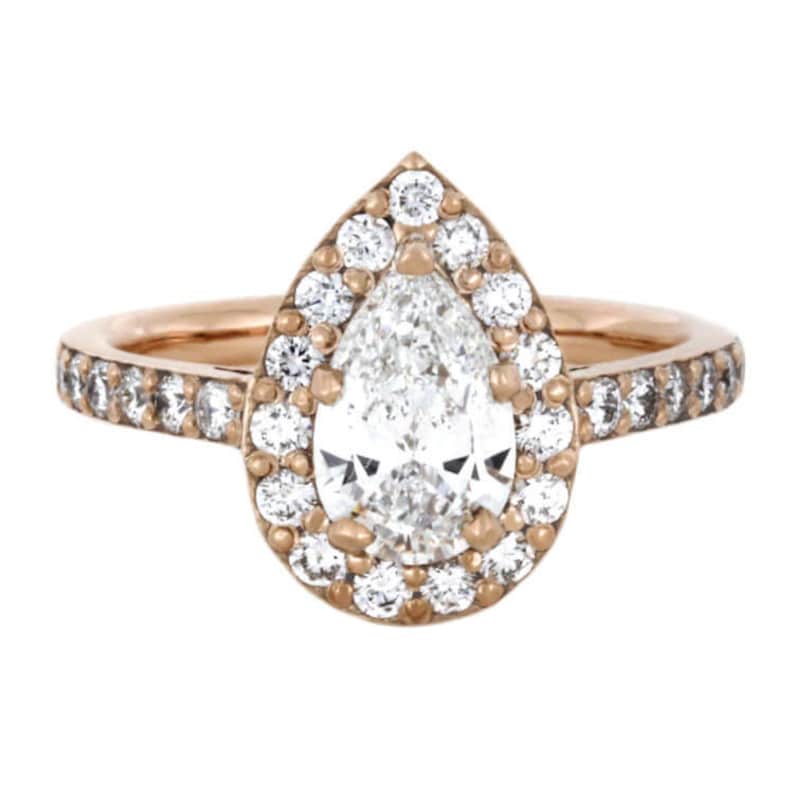 May include: A pear-shaped diamond engagement ring set in rose gold with a halo of smaller diamonds and a band of pave diamonds.