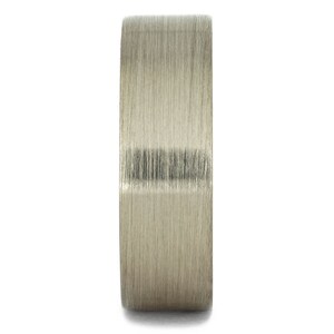 May include: A brushed silver ring with a wide band.