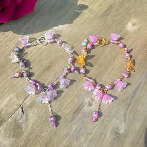purple butterfly beaded bracelets with flower and butterfly charms. beaded flower bracelets, beaded purple bracelets in silver and gold.