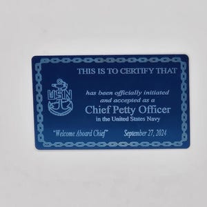 May include: A blue card with the text "THIS IS TO CERTIFY THAT" and "Chief Petty Officer in the United States Navy." The card also includes the text "Welcome Aboard Chief" and the date September 27, 2024.