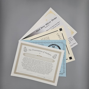May include: A collection of certificates, including a "Chief Petty Officer Pledge" and "The Presentation of Anchors" document. The certificates have decorative borders and text, with a navy theme.