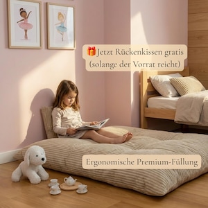 Op de afbeelding: Een beige corduroy vloerkussen met een getuft oppervlak, inclusief een wit pluche hondenspeeltje en een klein theeservies op de vloer. De tekstoverlays luiden: "Jetzt R&uuml;ckenkissen gratis (solange der Vorrat reicht)" en "Ergonomische Premium-F&uuml;llung".