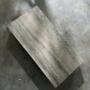 May include: A rectangular coffee table with a light grey and brown marble top. The table has a smooth, polished surface and a natural stone pattern.