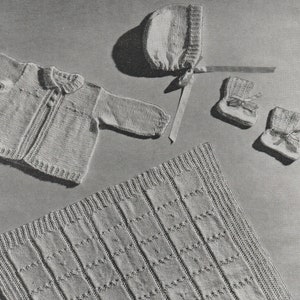 May include: A knitted baby set in white, including a cardigan, a bonnet, and booties. The set is laid out on a gray background.