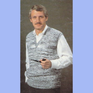 May include: A grey and white patterned knitted waistcoat with a V-neck. The waistcoat is worn over a white button-down shirt.