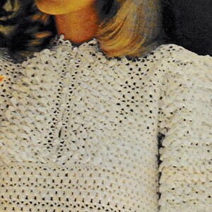May include: A white crocheted top with a textured, puffy design. The top has a high neckline and short sleeves. The sleeves have a scalloped edge.