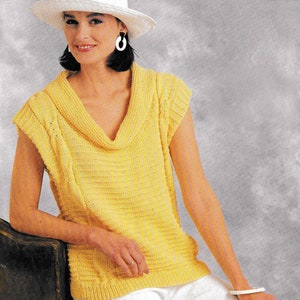 May include: A yellow sleeveless knitted top with a cowl neck. The top is made with a simple stitch pattern and has a relaxed fit.