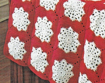 May include: A red and white crocheted blanket with a snowflake pattern. The blanket is folded over a wooden chest.