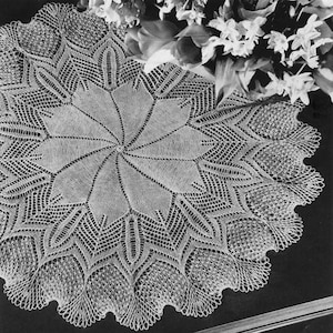 May include: A white crocheted doily with a delicate floral design. The doily is circular and has a scalloped edge.