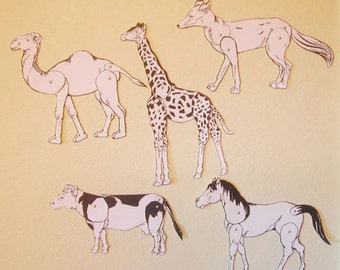 Puede incluir: Cinco marionetas de papel de animales, incluyendo un camello, una jirafa, un zorro, una vaca y un caballo. Las marionetas son todas blancas con contornos y detalles negros. Todas están en posición de pie.
