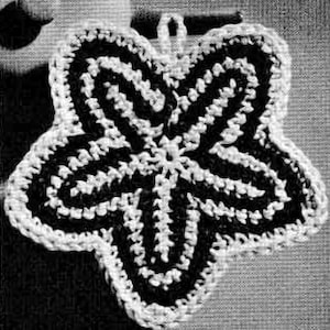 May include: A black and white crocheted star-shaped pot holder. The star has a five-pointed design with a center point.