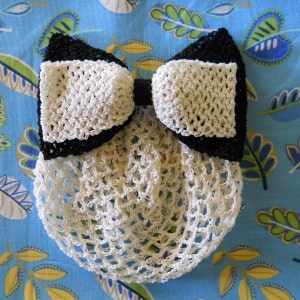 May include: A white crocheted hairnet with a black and white crocheted bow on top.