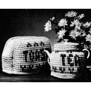 Puede incluir: Cubiertas de ganchillo blancas para una tostadora y una tetera. La cubierta de la tostadora tiene la palabra "Toast" escrita en ella y la cubierta de la tetera tiene la palabra "Tea" escrita en ella.