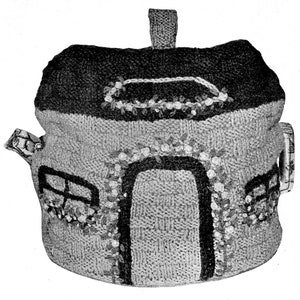 May include: A knitted house-shaped teapot cozy with a black roof, white trim, and a black door. The cozy has a small window on each side and a handle on the side.