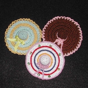 Puede incluir: Tres sombreros de ganchillo en diferentes colores y patrones. Los sombreros están hechos con una variedad de puntadas y tienen un aspecto delicado y femenino.