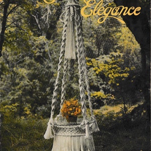 May include: A white macrame plant hanger with a fringe bottom and a tassel at the top. The hanger is hanging in a forest setting with green trees and foliage. The text "Macrame Elegance" is written in gold script at the top of the image.