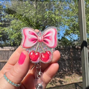 Coquette bow with cherry’s.Retractable glitter badge reel. Sweet treat for a teacher gift. Nurse-RN. Medical badge-student ID-work ID- cheer