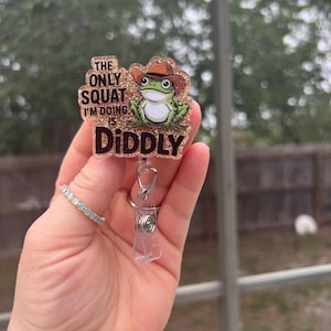 Le seul squat que je fais est diddly. Grenouille rigolote avec enrouleur de badge rétractable à paillettes et chapeau de cowboy. Enseignant-étudiant-titulaire d'une carte d'identité-employé de commerce