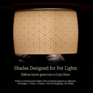 May include: A cylindrical lampshade with a geometric triangle pattern. The shade is a warm, off-white color and is designed to fit over pot lights. The text on the image reads "Shades Designed for Pot Lights" and "Diffuse harsh glare into a Cozy Glow."