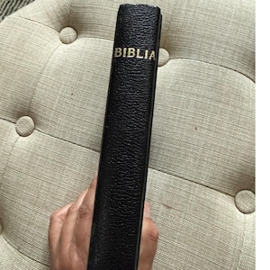 Biblia rumana antigua, tapa dura negra, libro religioso con lomo dorado. imagen 1