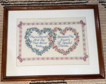 Cuadro vintage enmarcado con corazones florales bordados a punto de cruz y mensaje para amigos especiales.