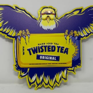 Peut inclure: Panneau jaune et bleu en forme d'aigle aux ailes déployées. L'aigle tient un rectangle jaune avec les mots "Twisted Tea Original" et "Hard Iced Tea". Les ailes et le corps de l'aigle sont violets.
