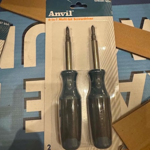 May include: A two-pack of Anvil 6-in-1 multi-bit screwdrivers in original retail packaging. Each tool features a dark blue handle and a silver metal shaft with a reversible bit. The cardboard backing displays the brand name and product details.