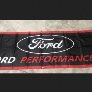 May include: Black banner with the Ford logo in white inside a black oval. The words "FORD PERFORMANCE" are in white and red. The banner has a red border.