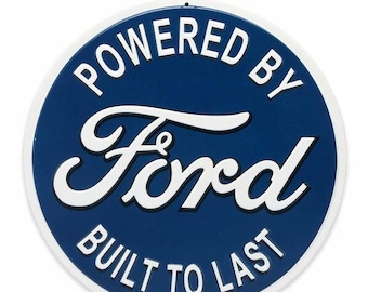 Op de afbeelding: Ronde blauwe en witte Ford-bord met de tekst "POWERED BY FORD BUILT TO LAST" in witte letters. Het bord heeft een witte rand en een metalen hanger aan de bovenkant.