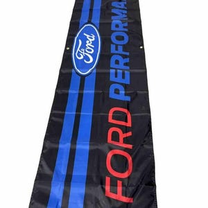 May include: A black banner with the words "FORD PERFORMANCE" in red letters and a blue oval with the word "Ford" in white letters. The banner has two blue stripes.