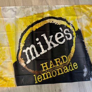 May include: A yellow and black flag with the text "Mike's Hard Lemonade" in a black circle.