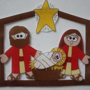 May include: A felt Christmas nativity scene with a yellow star, a brown manger, and three figures: Joseph, Mary, and baby Jesus. The figures are dressed in red and yellow robes.