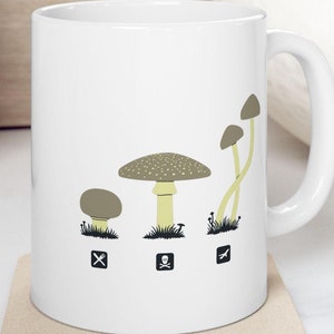 May include: White ceramic mug with a graphic of three mushrooms of different sizes. The mushrooms are labeled with a fork and knife, a skull and crossbones, and an airplane. The text "Shroom Queens" is printed on the mug.