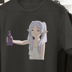 May include: A black t-shirt with a white anime character holding a purple bottle. The character has long white hair and is wearing a white towel.