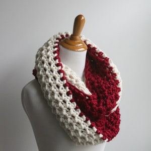 May include: A white and burgundy crocheted infinity scarf. The scarf is made with a chunky yarn and has a simple, yet stylish design.