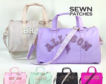 Puede incluir: Cinco bolsas de viaje de diferentes colores con nombres personalizados en letras de purpurina dorada y una correa de chevron blanca y dorada. Los nombres en las bolsas son: 'BRIAR', 'ALLISON', 'MEGAN', 'NAMI' y 'CHLOE'. Las bolsas están hechas de un tejido suave y ligero y tienen un cierre de cremallera.