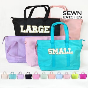Può includere: Un set di dieci borse tote in vari colori, tra cui rosa, blu, verde e giallo. Le borse hanno un patch cucito che dice "SEWN PATCHES". Alcune borse hanno la parola "LARGE" o "SMALL" scritta su di esse con lettere di glitter dorate.