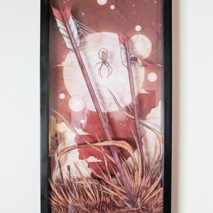 May include: Framed illustration of three arrows stuck in the ground with a spider web and a spider in the background. The background is a red and brown color with white clouds and stars.