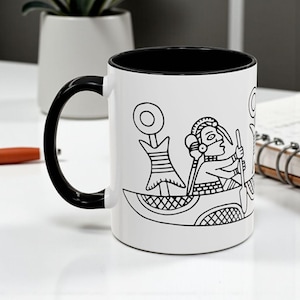 May include: White ceramic mug with a black interior, handle, and rim. The mug features a black and white illustration of a person in a boat with a paddle, and other decorative elements. The mug is on a white surface.