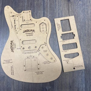 May include: A tan-colored Jaguar pickguard template and a smaller routing template. The main template has the text "JAGUAR Pickguard Template" and measurements in inches. The body thickness should be 1.75 inches.
