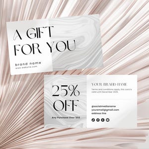 May include: Gift cards with a marble design and the text "A GIFT FOR YOU" and "25% OFF." The cards also include the brand name, website, and social media information. The background is a light pink, textured surface.