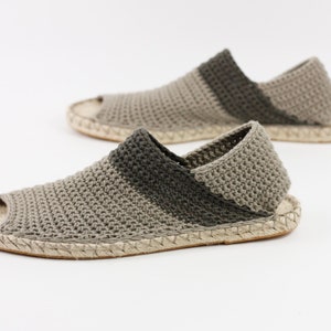 May include: A pair of beige and green crocheted espadrille sandals with a woven jute sole.
