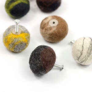 May include: Assortment of colorful felt knobs with a screw attached to each. The knobs are in various shades of brown, gray, yellow, and black.