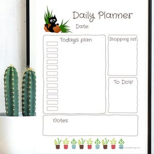 Könnte beinhalten: Ein weißer Tagesplaner mit schwarzem Rahmen. Der Planer enthält Abschnitte für "Today's plan", "Shopping list" und "To Do's!" Eine Cartoon-Katze sitzt auf einem braunen Topf mit grünem Gras. Der untere Teil des Planers zeigt Topfpflanzen.