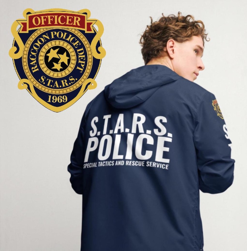 May include: A navy blue jacket with a white "S.T.A.R.S. POLICE" logo on the back. The logo is surrounded by the text "SPECIAL TACTICS AND RESCUE SERVICE". The jacket has a hood and a zip closure. A gold badge with the text "RACCOON POLICE DEPT. S.T.A.R.S. 1969" is visible on the left side of the image.