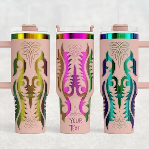 May include: Three insulated tumblers with handles and straws. Each tumbler is light pink with a colorful, ornate design. The designs feature a central vertical pattern with a floral motif. The tumblers have a handle and a lid with a straw.