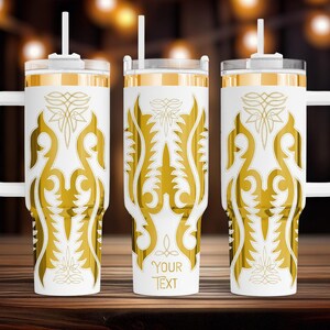 May include: Three white insulated tumblers with gold decorative patterns and handles. Each tumbler has a white lid, a straw, and the words "YOUR TEXT" printed on the front. The tumblers are on a wooden surface.
