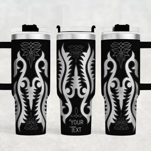 May include: Black insulated tumbler with a silver ornamental design. The tumbler has a handle, a lid, and a straw. The text "YOUR TEXT" is printed on the tumbler. The design is symmetrical and features floral and geometric elements.