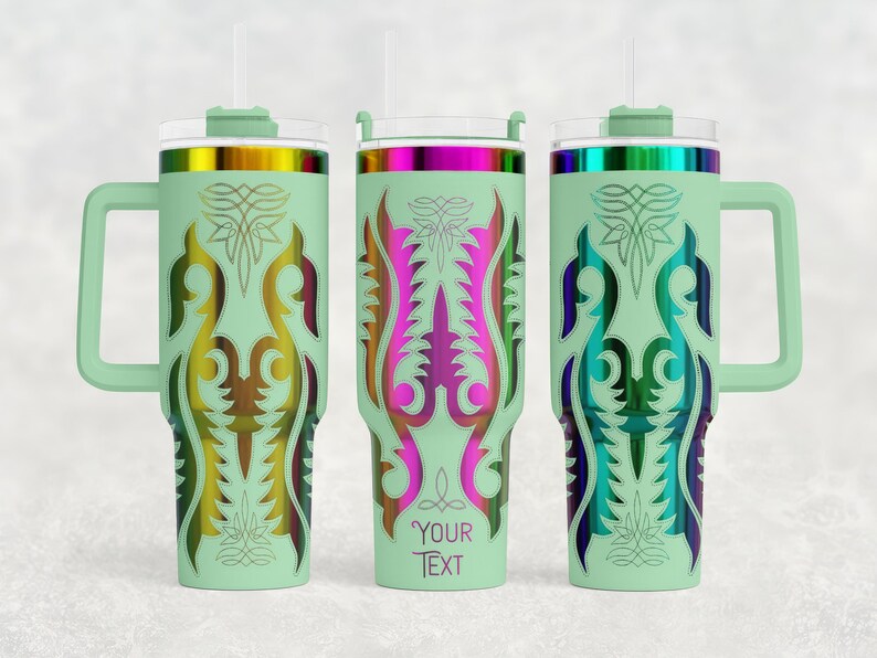May include: Three mint green insulated tumblers with handles, lids, and straws. Each tumbler features a unique, colorful, symmetrical design. The middle tumbler has the text "YOUR TEXT" at the bottom. The designs include gold, pink, blue, and green.